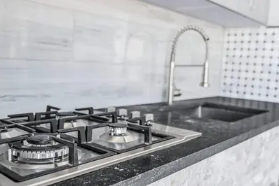 a kitchen counter with a stove and a sink at 3 2 Family friendly Brand New Home w Pool in Miami