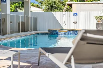 a swimming pool with a chair in front of a fence at 3 2 Family friendly Brand New Home w Pool in Miami