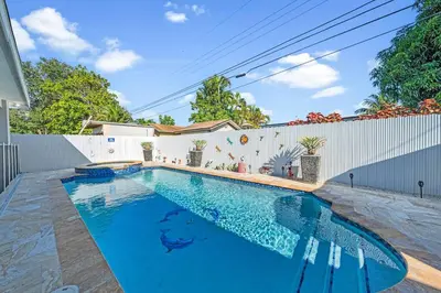 a swimming pool in front of a white fence at 3 2 Family friendly Brand New Home w Pool in Miami