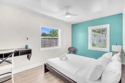 a room with a bed and a desk and two windows at Bluewave Bungalow - #2 Charming & Relaxing 2 1 in Dania Beach