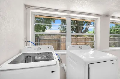 a kitchen with a washing machine and a window at Bluewave Bungalow - #2 Charming & Relaxing 2 1 in Dania Beach