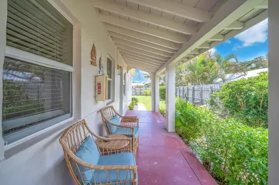 a porch with two chairs and a window at Bluewave Bungalow - #2 Charming & Relaxing 2 1 in Dania Beach