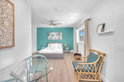 a bedroom with a bed and a glass table at Blue Wave Bungalow - 1 1 - Stylish in Dania Beach