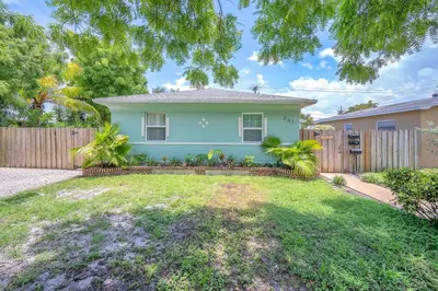 a house with a fence and a yard at Blue Wave Bungalow - 1 1 - Stylish in Dania Beach