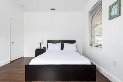 a bedroom with a bed with white sheets and a window at Casa Havana Renovated 3 2-Near Brickell&Downtown in Miami