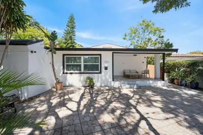 a white house with a patio with a couch at Casa Santorini - Chic 4 2 near Grove & Brickell in Miami