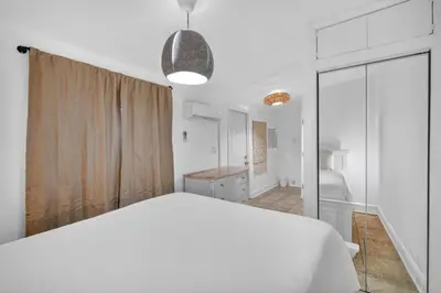 a white bedroom with a large white bed and a bathroom at Casa Santorini - Chic 4 2 near Grove & Brickell in Miami