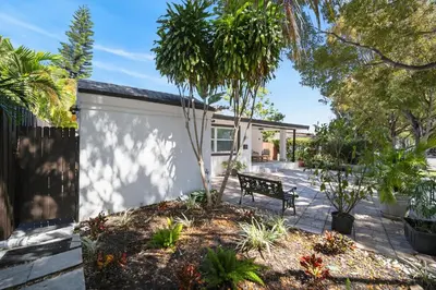 a garden with a bench in front of a house at Casa Santorini - Chic 4 2 near Grove & Brickell in Miami