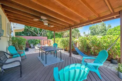 a patio with a table and chairs and a ceiling fan at Casa Santorini - Chic 4 2 near Grove & Brickell in Miami