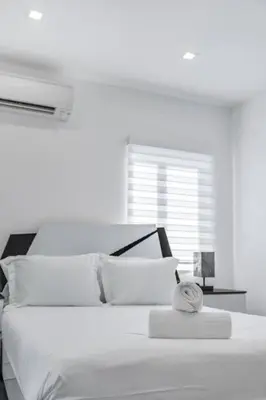 a white bedroom with a bed with a clock on it at Homey Studio near the Airport and Water Park in Miami
