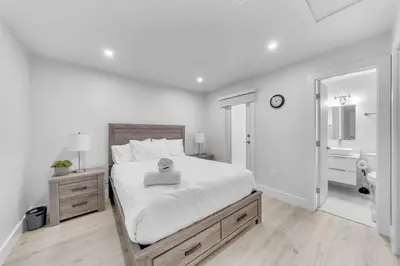 a white bedroom with a bed and a bathroom at Mykonos Home - 2 2 Cozy and Charming Duplex in Miami