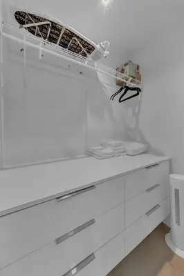 a white closet with white drawers and a shelf at Mykonos Home - 2 2 Cozy and Charming Duplex in Miami