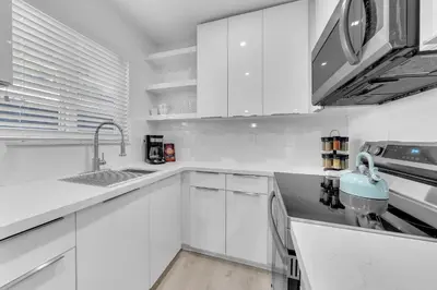 a white kitchen with white cabinets and a sink at Mykonos Home - 2 2 Cozy and Charming Duplex in Miami