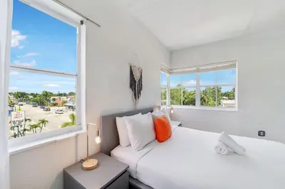 a white bedroom with a bed and a window at Treehouse Hotel in Miami