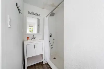 a white bathroom with a sink and a mirror at Treehouse Hotel in Miami