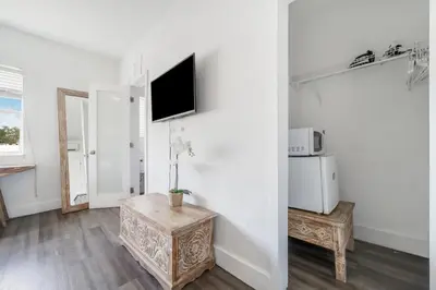 a living room with a table and a tv on a wall at Treehouse Hotel in Miami