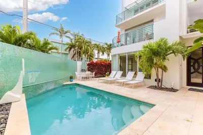 a swimming pool in front of a house at 4-Bed + Den with pool in Las Olas Ft Lauderdale in Fort Lauderdale