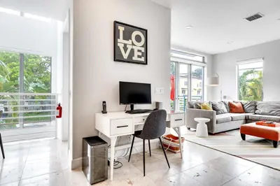 a living room with a desk with a computer at 4-Bed + Den with pool in Las Olas Ft Lauderdale in Fort Lauderdale