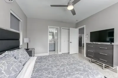 a bedroom with a bed and a flat screen tv at Sunshine Manor 2009 in Fort Lauderdale