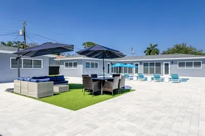 a patio with a table and chairs and umbrellas at Sunshine Manor 2013 in Fort Lauderdale