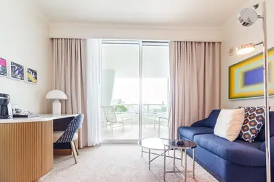 a living room with a blue couch and a table at Fontainebleau in Miami Beach
