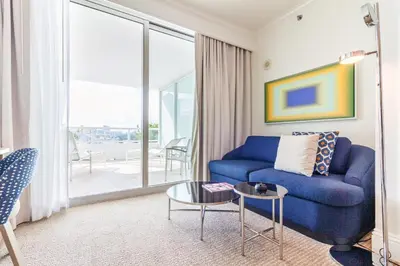a living room with a blue couch and a table at Fontainebleau in Miami Beach