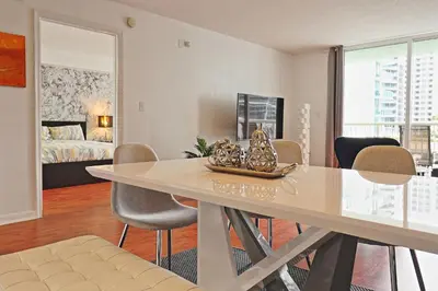 a dining room with a table and chairs and a bedroom at Upscale Apartment in the Heart of Brickell in Miami