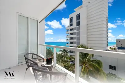 a balcony with chairs and a view of the ocean at FontaineBleau Resort Balcony w Ocean and City View in Miami Beach