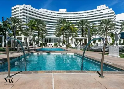 a swimming pool in front of a large building at FontaineBleau Resort Ocean plus Bay View w Balcony in Miami Beach