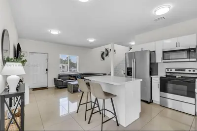 a kitchen with a counter and chairs in a room at The 305 in Miami