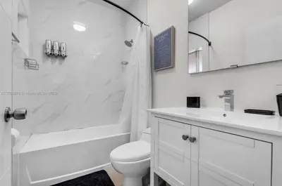 a white bathroom with a toilet and a sink at The 305 in Miami