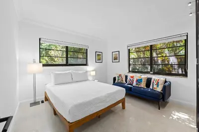 a bedroom with a bed and a blue couch at 7 Minutes to Beach Saltwater Pool Open Floor Plan in Fort Lauderdale