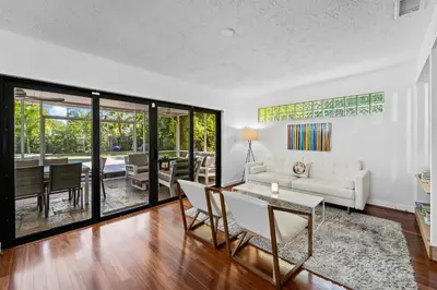 a living room with a white couch and a table at 7 Minutes to Beach Saltwater Pool Open Floor Plan in Fort Lauderdale