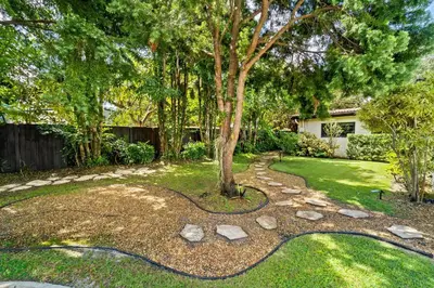a garden with a tree and rocks at 7 Minutes to Beach Saltwater Pool Open Floor Plan in Fort Lauderdale