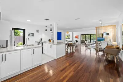 an open kitchen and living room with white cabinets at 7 Minutes to Beach Saltwater Pool Open Floor Plan in Fort Lauderdale