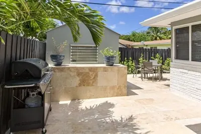 a backyard with a grill and a fence at WiltonPlex A in Fort Lauderdale