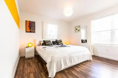a white bedroom with a bed and a window at 1 Bedroom 5 minutes walk to Beach on Washington Ave in Miami Beach