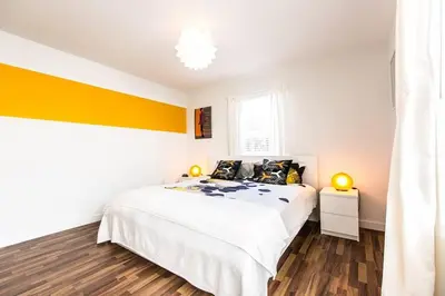 a bedroom with a white bed and a yellow accent wall at 1 Bedroom 5 minutes walk to Beach on Washington Ave in Miami Beach