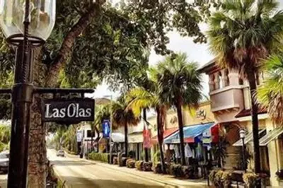 a street sign in front of a street with palm trees at Mango Manor - Walk to Las Olas! in Fort Lauderdale