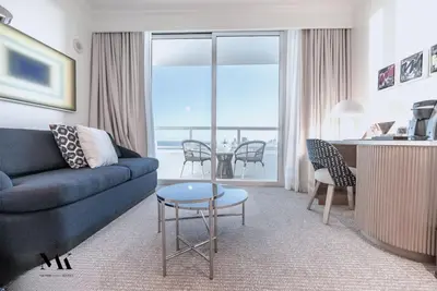 a living room with a blue couch and a table at FontaineBleau Resort High Floor w Ocean Views in Miami Beach