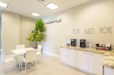 a dining room with a table and chairs and a white counter at Coral Gables 2br w wd pool gym near shops MIA-83 in Miami