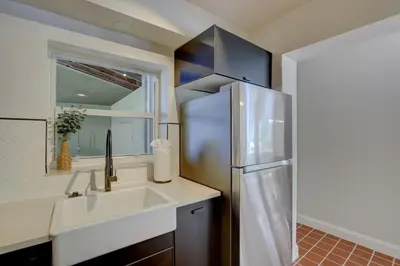 a kitchen with a stainless steel refrigerator next to a sink at Tranquil Poolside Bliss Pergola Deck Turf Yard in Fort Lauderdale