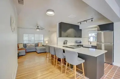 a kitchen with a counter and some chairs in a room at Tranquil Poolside Bliss Pergola Deck Turf Yard in Fort Lauderdale