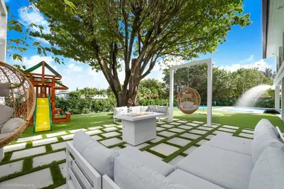 a patio with a tree and a swing at The World's Mansion - Game Room, 9 Bedrooms, Htd Pool, Mini Golf, BBQ in Tamiami