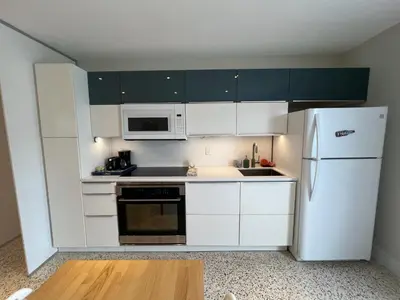 a kitchen with white cabinets and a white refrigerator at Cozy house close Brickell in Miami