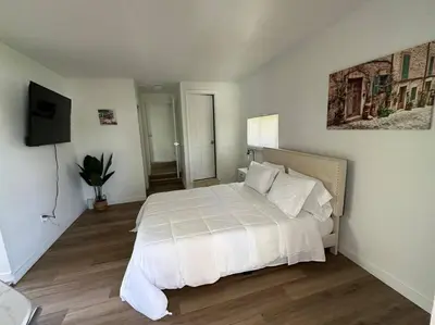 a bedroom with a white bed and a flat screen tv at Stylish Studio Brickell/Little Havana@ItalianPlaza in Miami