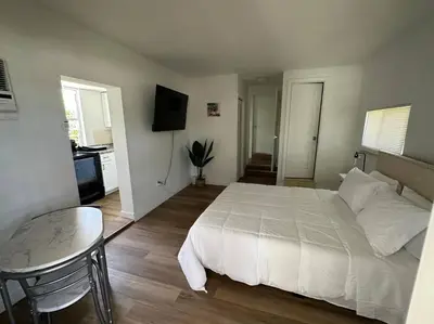 a bedroom with a large white bed and a table at Stylish Studio Brickell/Little Havana@ItalianPlaza in Miami