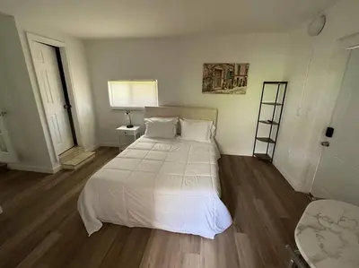 a bedroom with a large white bed and wooden floors at Stylish Studio Brickell/Little Havana@ItalianPlaza in Miami