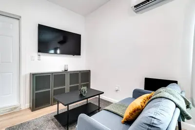 a living room with a couch and a tv on a wall at Coral Way Studio in quiet area Fast Internet Shen 1 in Miami