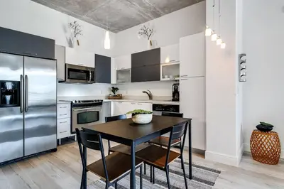 a kitchen with a table and a stainless steel refrigerator at Beautiful Loft in Downtown Miami For 4 people 2208 in Miami
